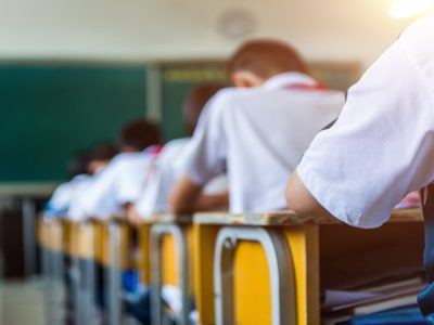 Rear view of middle school students studying in classroom